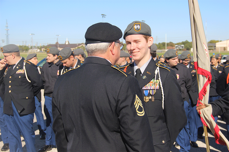 Before the Veterans Day Ceremony, Sergeant Miller jokes around with senior Alex Zeizinger.