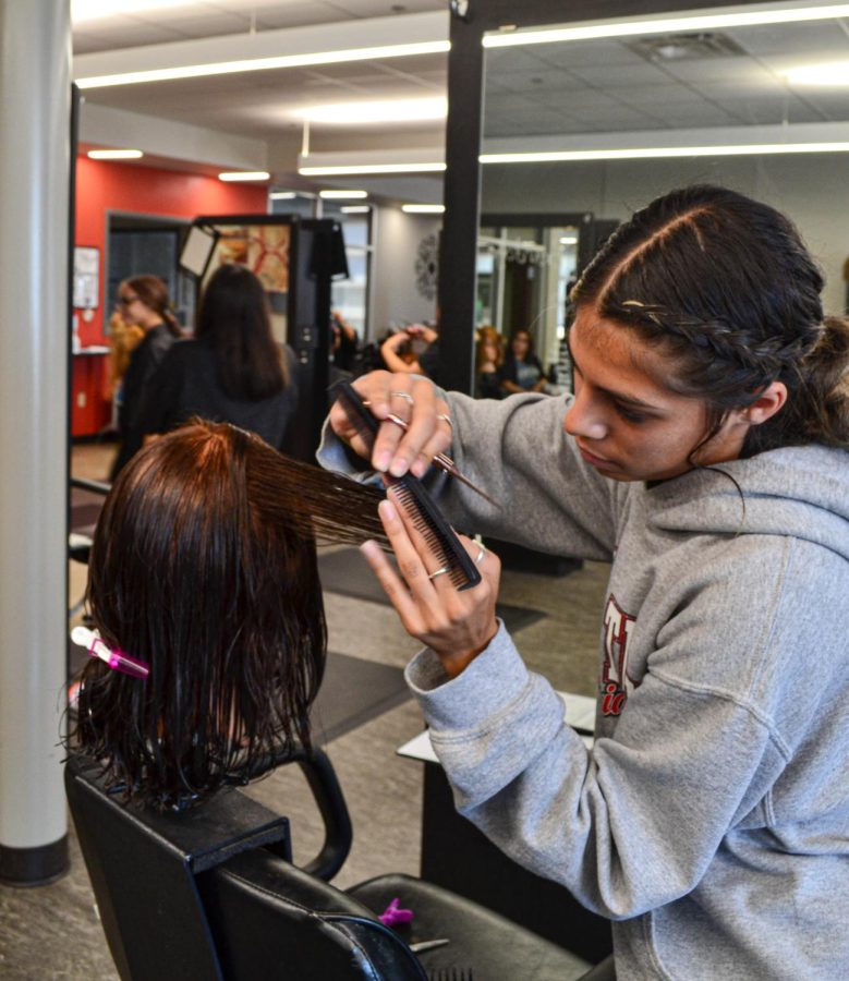 Kensee Lopez works on styling hair during her class at the CEC. 
