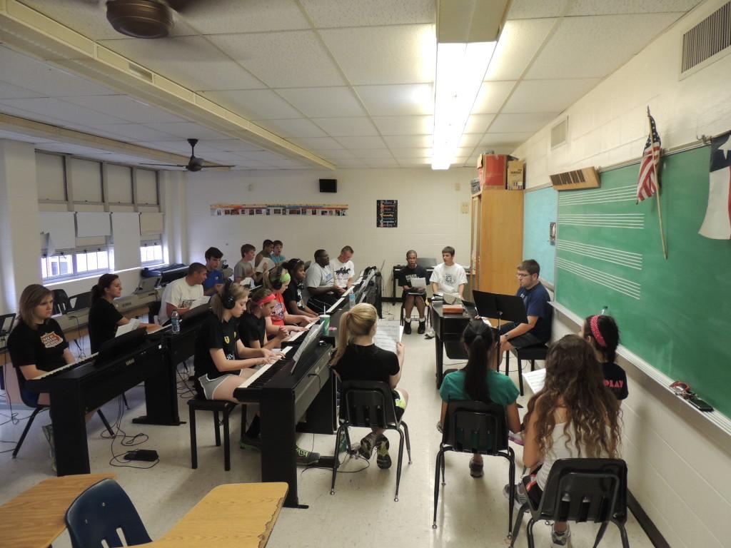 Show Choir rehearses in the piano room. The students practice their scales as Mr. Mayfield directs. Photo by Angel Quevy.