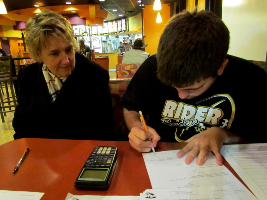 Mrs.Ramirez helps junior Garrett Linn with Math Models homework. 