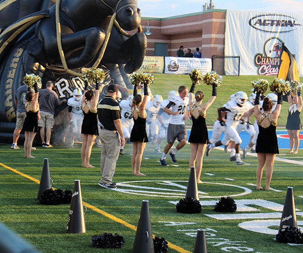Before the game against Abilene Cooper the varisty football team runs out while the dance team dances to the Alma Mater on Aug. 28, 2014.