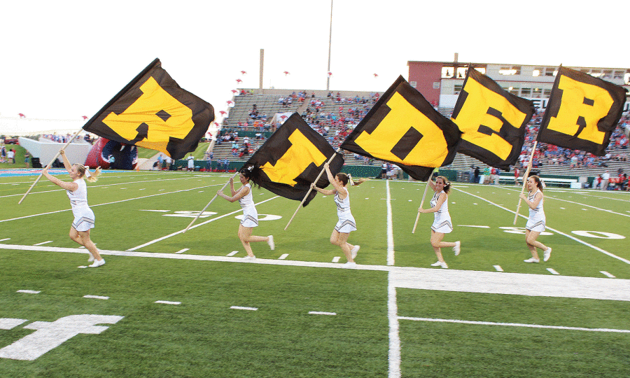 After a touchdown at the game against Abliene Cooper the cheerleaders take the flags that spell Rider and run them across the field on Aug. 28, 2014. The final score was Rider 21 Abliene Cooper 7. 