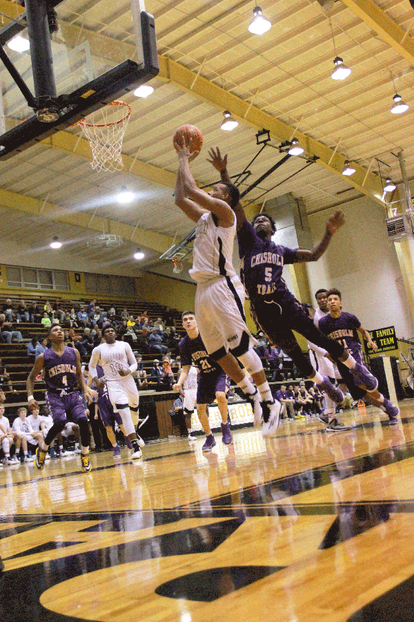 Senior Qua Pope jumps before successfully dunking the ball, scoring two points against Chisholm Trail on  Jan. 27, 2015.