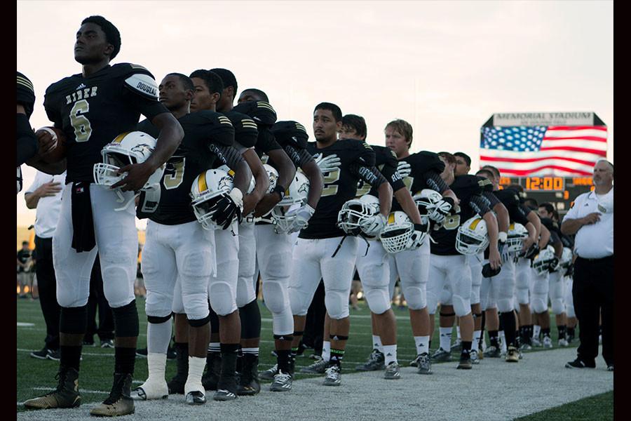 Senior quarterback Desmond Jackson stands along the sidelines and shows respect during the National Anthem. “I always say a prayer and prepare myself mentally for the game,” Desmond said.