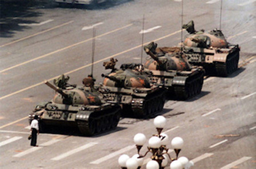 The most infamous photo of the Tiananmen Square massacre. Here a lone man stands in-front of a column of Chinese tanks. 4/15/1989