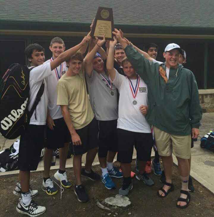The varsity tennis boys hold up the District First Place team trophy. 