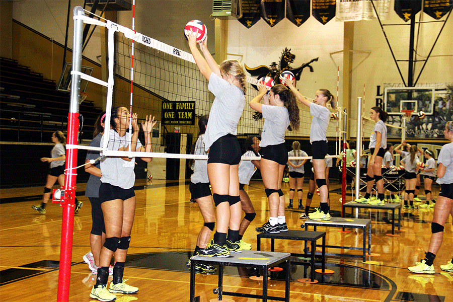 Varsity and JV girls practice different drills like blocking the volleyball during eighth period and after school practice.