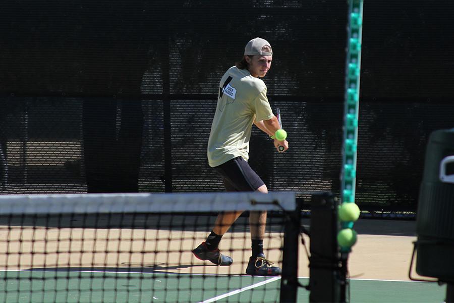 Graham Dunkelberg prepares to hit a backhand while warming up for the Denton High match.