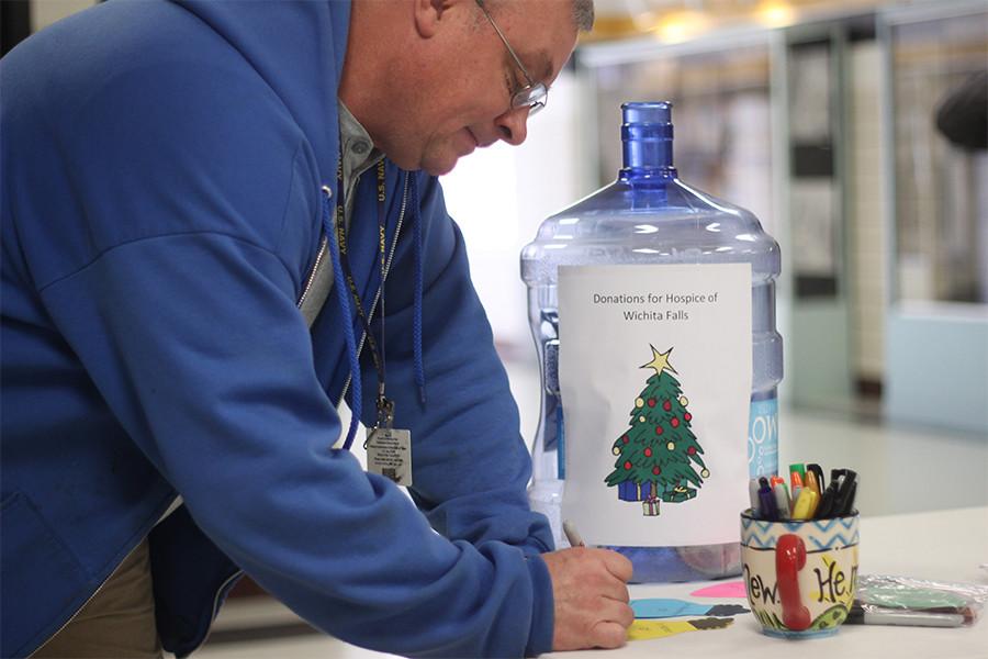 Paraprofessional Larry Foster writes two lightbulbs for his parents.