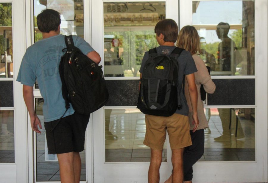 Students enter through the front doors after new policy change.