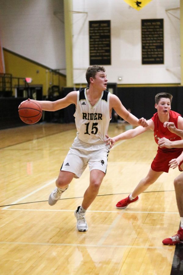 Senior Carson Sager keeps the ball away from his opponents during a game against Graham.