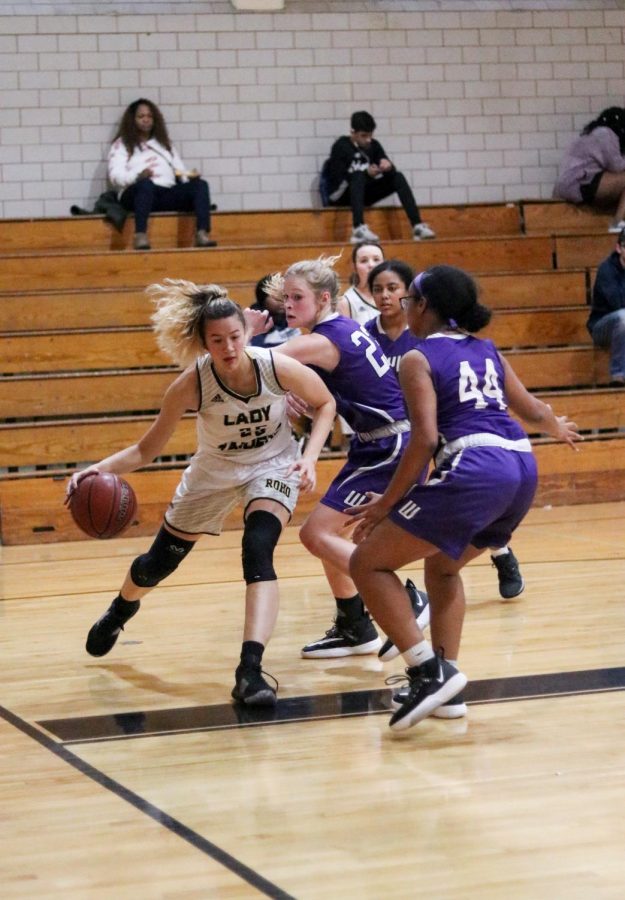 Senior Kaeli Donaldson tried to get away from three girls on the opposing team at a game during the 2019-2020 season.
