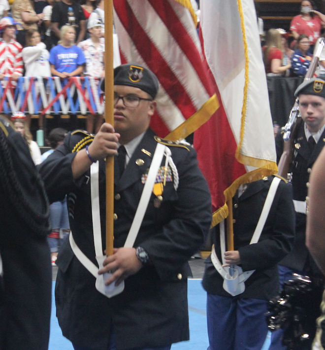 Elijah Aguon holds the American flag during a recent pep rally. Aguon is Rider's highest-ranking JROTC officer. 