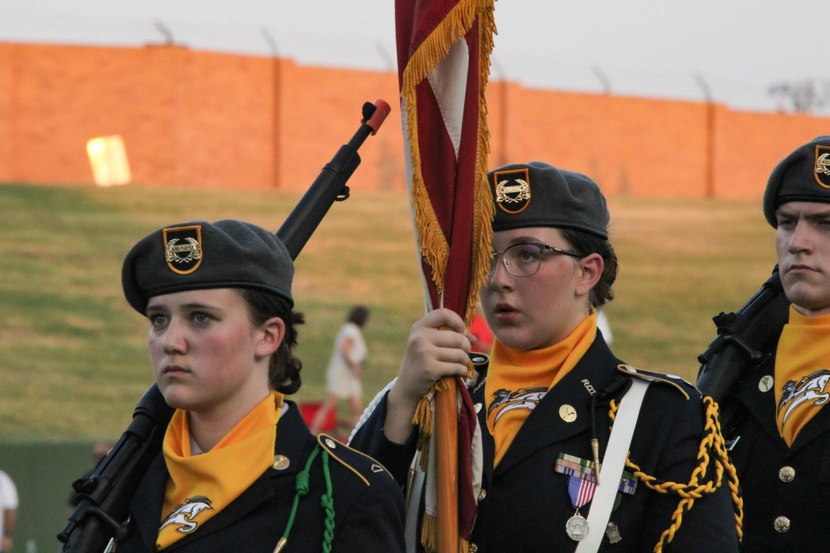 Malea Rierson and Madayson Atkinson march on the Memorial Stadium turf in August before the playing of the national anthem. 