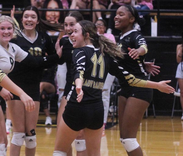 Emily Music celebrates a point with her teammates during a Lady Raider volleyball match this season. 
