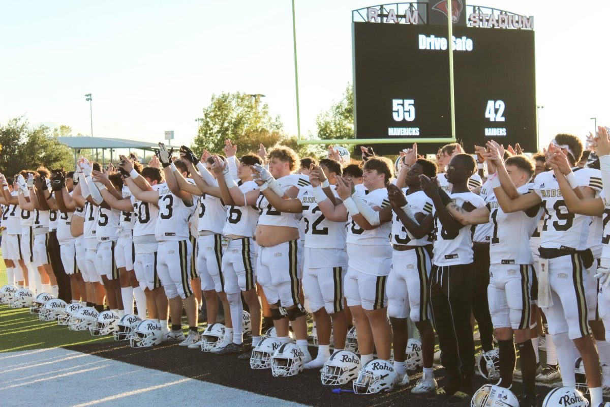 The+Raiders+raise+their+hands+to+the+sky+during+the+alma+mater+at+the+end+of+Rider%E2%80%99s+final+football+season.+The+Raiders+finished+10-3+and+won+their+first+district+title+since+2008.